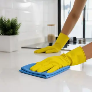 Gloved hands wiping a kitchen counter