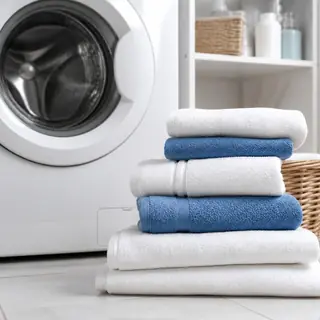 Folded towels beside a washing machine